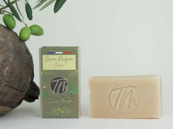 présentation du savon parfum coco sur fond beigne avec coco et branche d'olivier