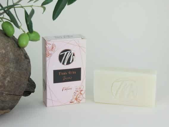 présentation du savon naturel sur fond beigne avec coco et branche d'olivier