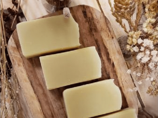 barre de savon artisanaux et surgras présentés sur une planche de bois