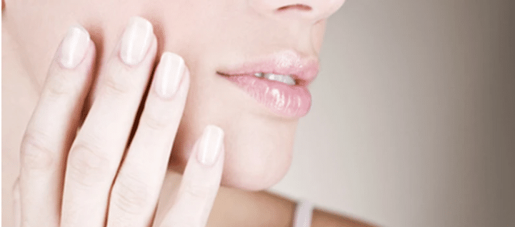 une main touche son visage